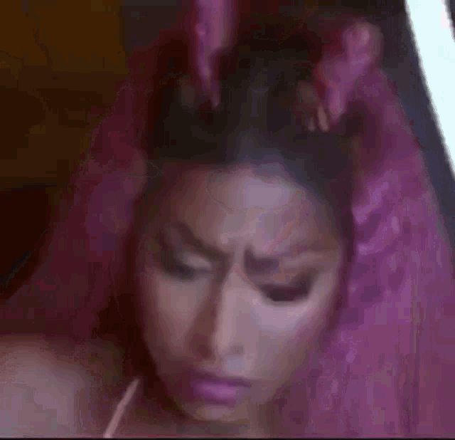 a blurry picture of a woman 's face with pink hair