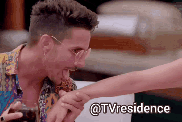 a man licking a woman 's foot with the words @tvresidence written below him
