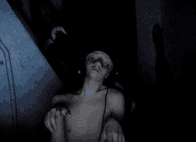 a person without a shirt in a dark room