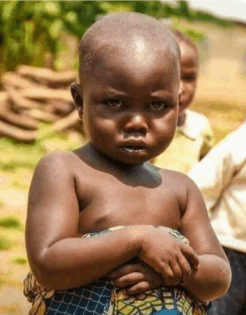 a baby without a shirt is making a funny face with his hands folded