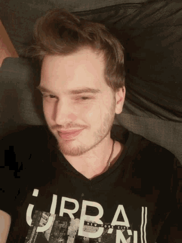 a man wearing a black shirt that says urban is smiling
