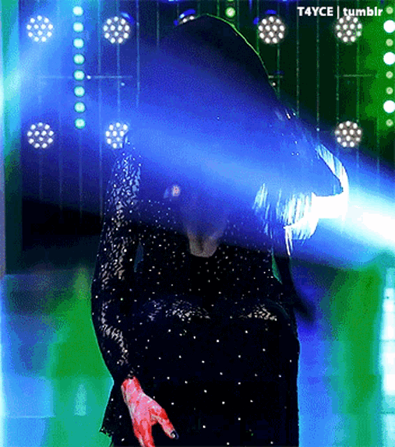 a woman in a black dress is kneeling down in front of a bunch of lights and a tumblr link