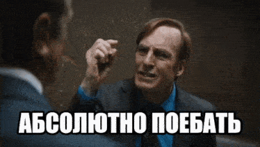 a man in a suit and tie is talking to another man in a dark room with a caption in russian