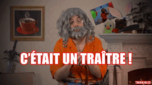 a man with a beard is sitting in front of a fireplace with the words " c'était un traitre " written in red