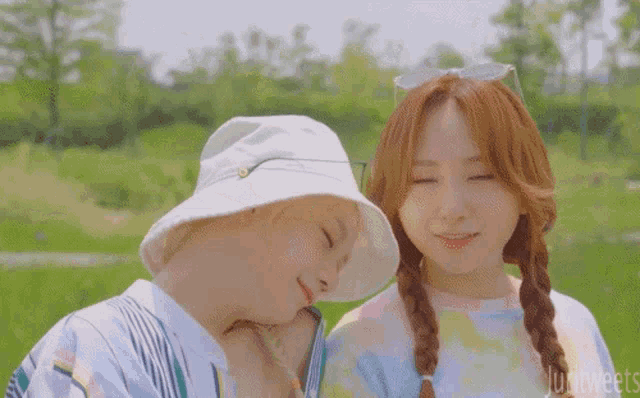 a couple of girls are standing next to each other in a park .