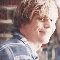 a young man in a plaid shirt is smiling .