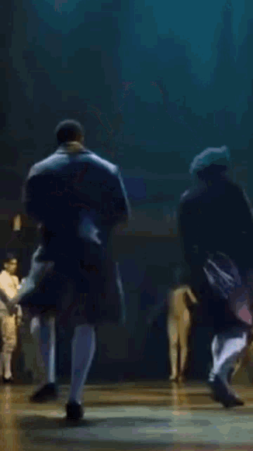 a couple of men are dancing together on a stage .
