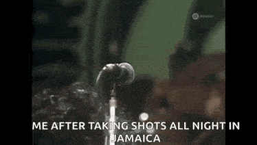 a man is singing into a microphone with the words `` me after taking shots all night in jamaica '' written on the screen .