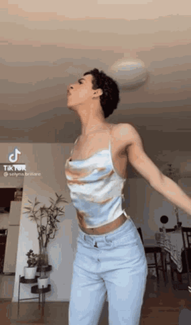 a woman is dancing in a room with her arms outstretched .