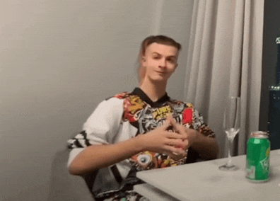a man sitting at a table with a can of sprite