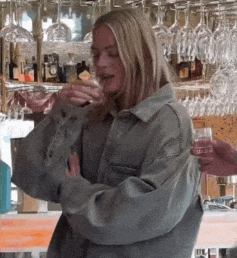a woman is drinking a glass of wine in a restaurant .