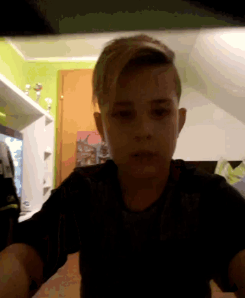 a young boy in a black shirt is making a funny face