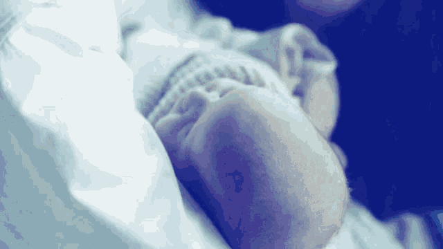 a person is holding a baby in their arms and the baby is sleeping