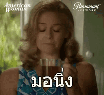 a woman is holding a cup of coffee and a paramount network logo is behind her