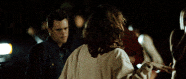 a woman in a white jacket is dancing in a crowd .