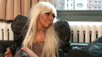 a woman with blonde hair is sitting on a black couch