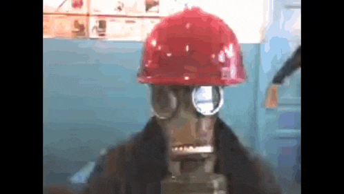 a person wearing a gas mask and a red hard hat