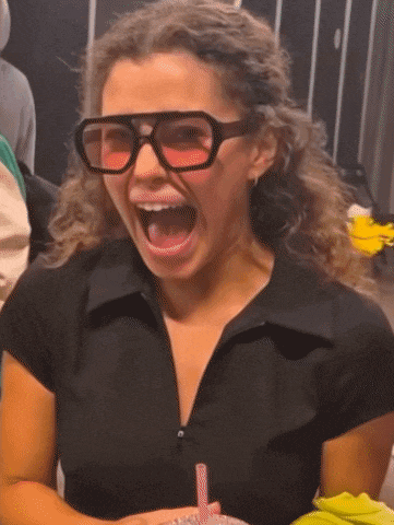 a woman wearing sunglasses and a black shirt has her mouth open