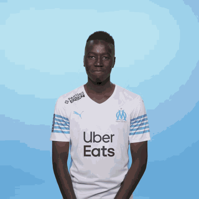 a man wearing an uber eats shirt is clapping