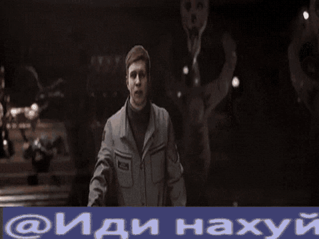 a man smoking a cigarette in front of a sign that says ' @ иди нахуй ' on it