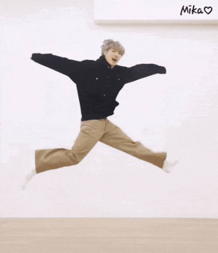 two people are jumping in the air with the word mika written on the wall