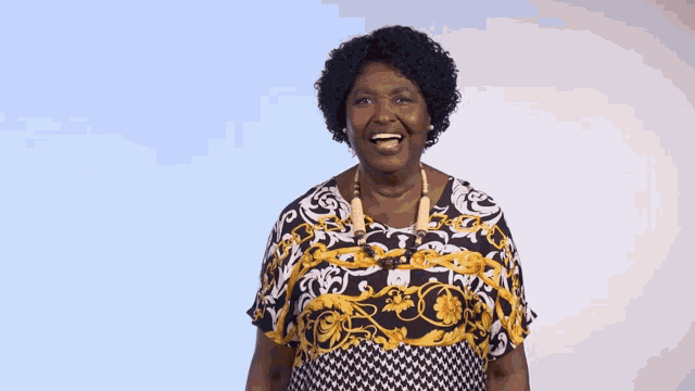 an elderly woman wearing a black and gold dress is laughing