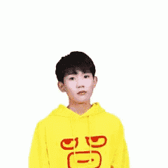 a young boy wearing a yellow hoodie with chinese writing on it is shrugging his shoulders