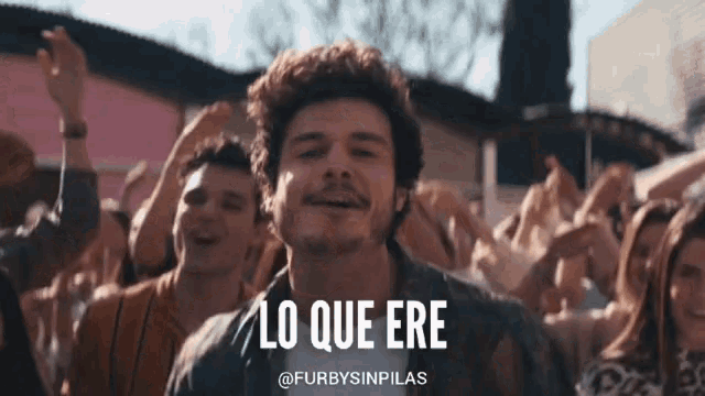 a man in a crowd with the words lo que ere on the bottom