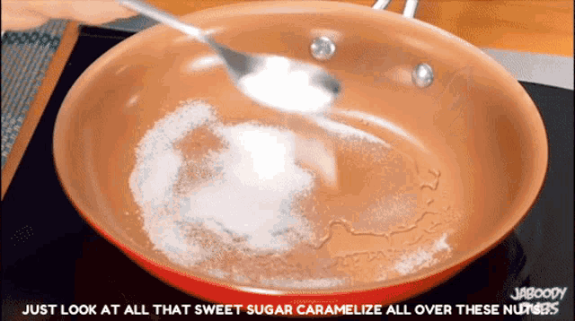 a frying pan with sugar and a spoon in it with the words just look at all that sweet sugar caramelize all over these nuts
