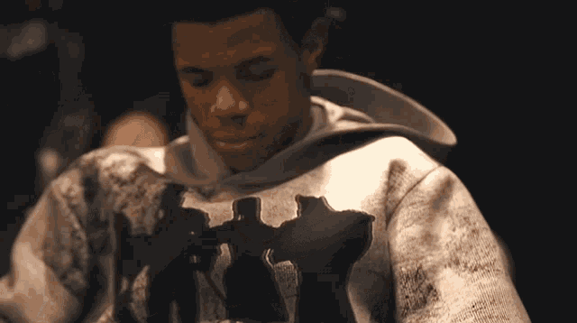 a man wearing a hoodie with a silhouette of a group of people on it