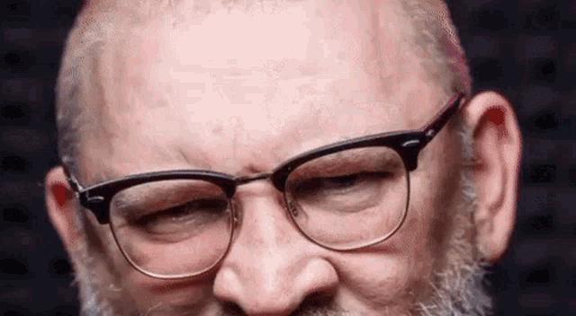 a man with a beard and glasses is making a face .