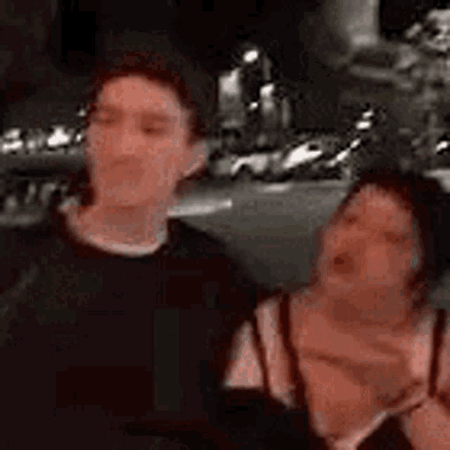 a man and a woman are standing next to each other on a street .