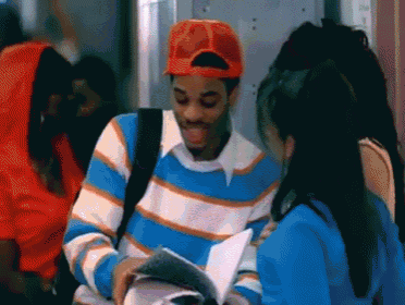 a man in an orange hat is reading a book to a girl