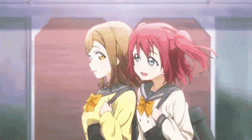 two anime girls with red hair are standing next to each other in front of a building .