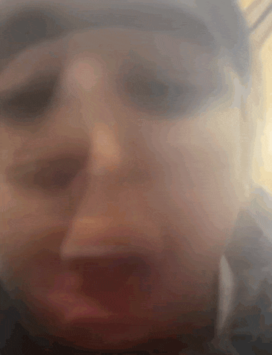 a blurry photo of a person 's face with a hat on