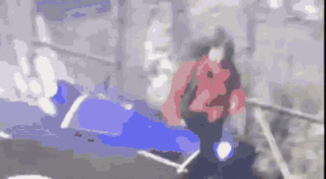 a blurry image of a person in a red jacket walking down stairs