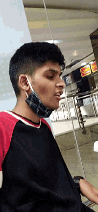 a young man wearing a face mask is smiling in front of a burger king