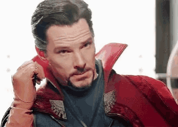 a man with a beard is wearing a red coat and gloves .