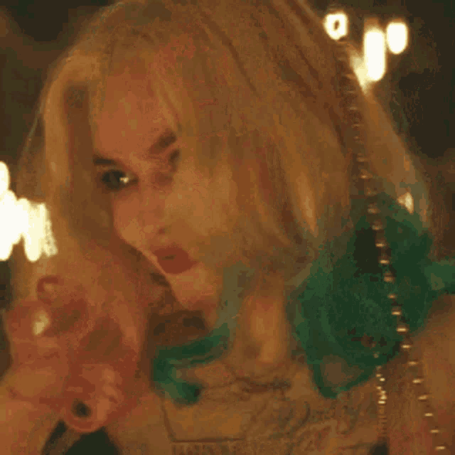 a woman in a suicide squad costume is laughing and saying puddin ' !