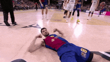 a basketball player with the number 8 on his shorts lays on the floor