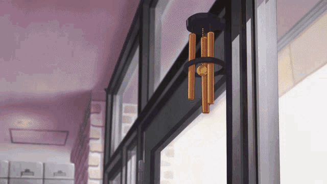 a wind chime hangs from a window in a room