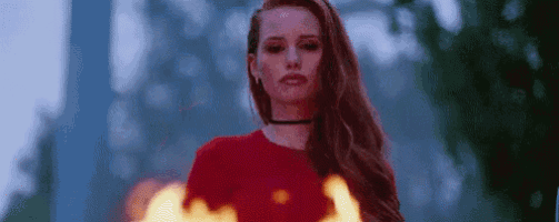 a woman is standing in front of a fire .