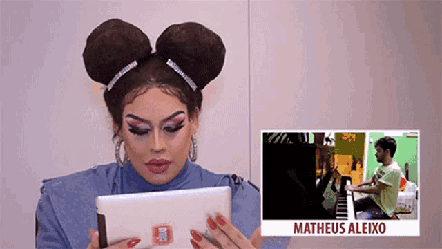a drag queen is looking at a tablet next to a picture of matheus aleiko playing a piano