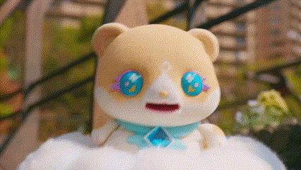a stuffed animal with blue eyes and a necklace is sitting on a cloud .
