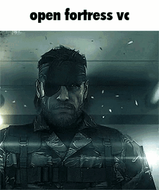a man in a military uniform and sunglasses is standing in a dark room with the words `` open fortress vc '' above him .