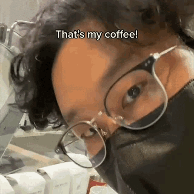 a man wearing glasses and a mask says that 's my coffee ..