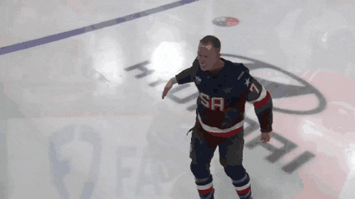 a man in a usa hockey jersey stands on a rink