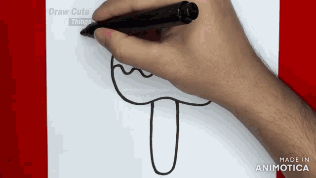 a person is drawing a mushroom on a piece of paper with a marker