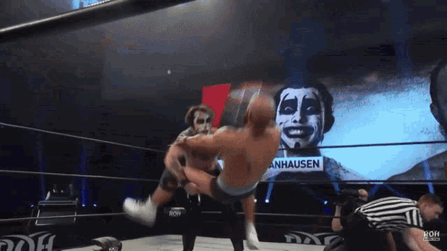 a man in a wrestling ring with a sign that says anhausen on it