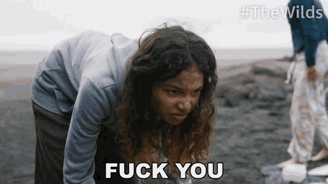 a woman on a beach with the words fuck you above her